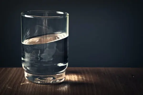 Glass of filtered water being poured, representing fluoride-free drinking water