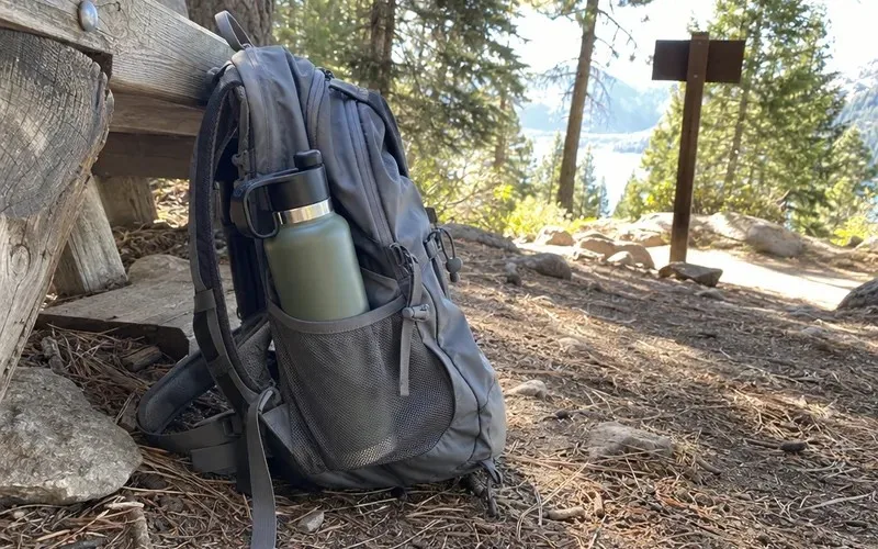 Tall insulated water bottle sticking out of a hiking backpack side pocket